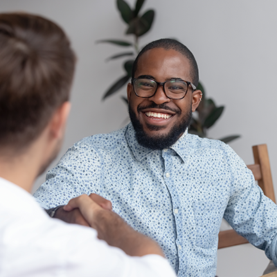 Man smiling and shaking hands with someone