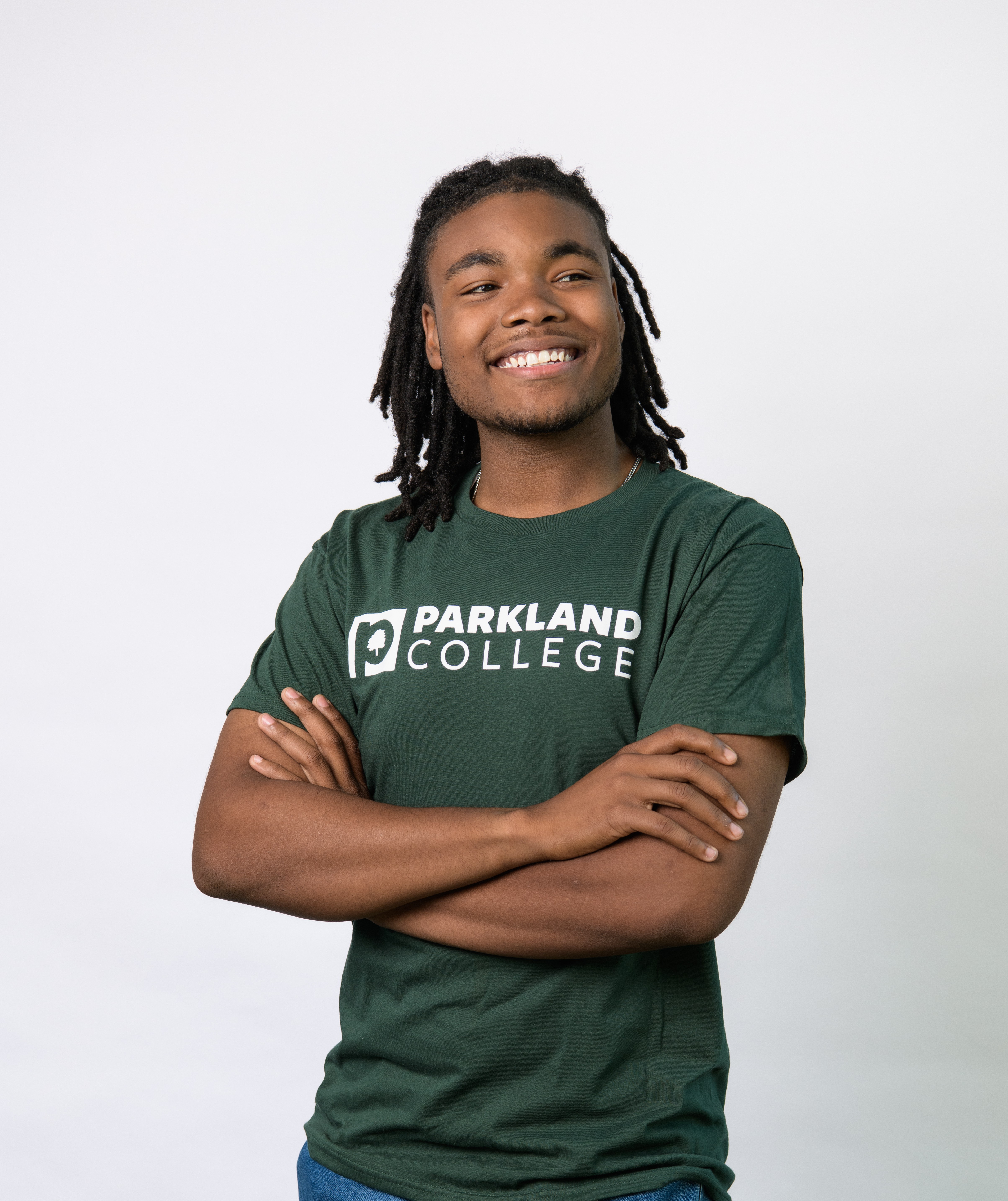 Smiling student wearing a green Parkland t-shirt 