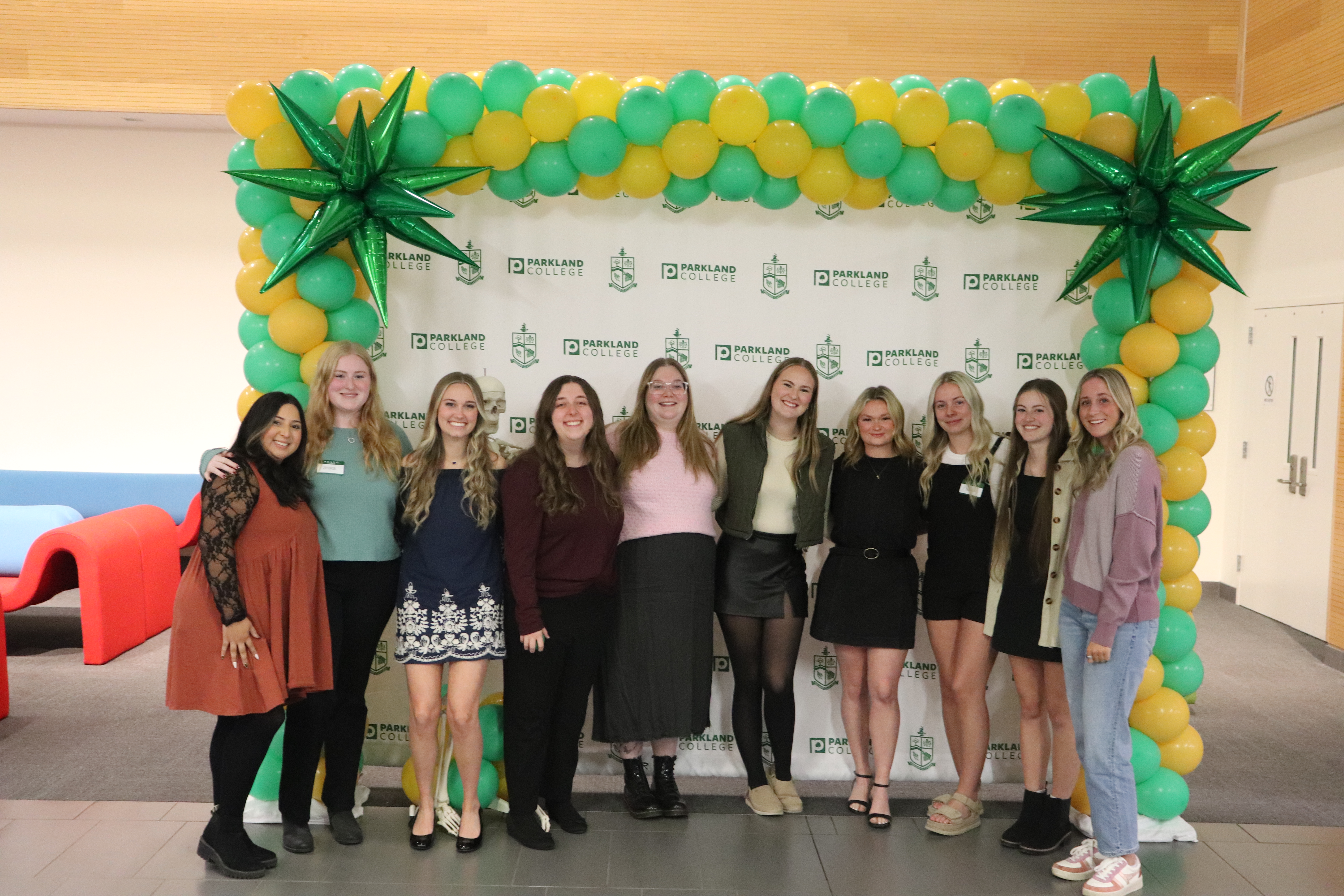 A group of radiologic technology alumni in front of a parkland backdrop.