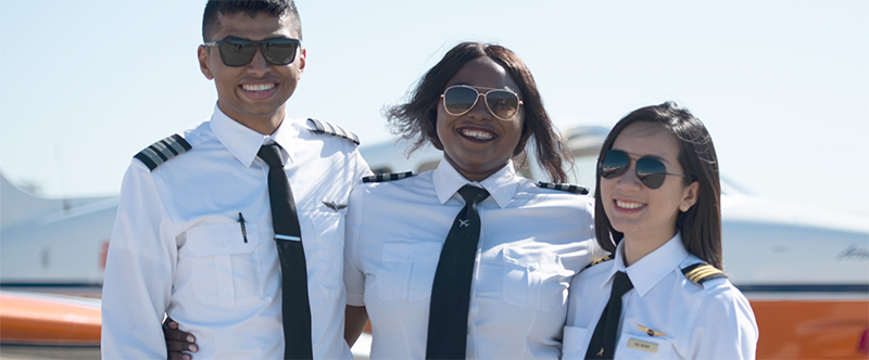 Parkland College aviation students smiling in front of an aircraft