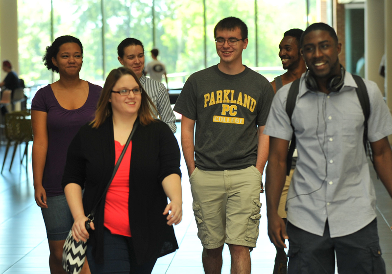 six students smiling and walking on campus