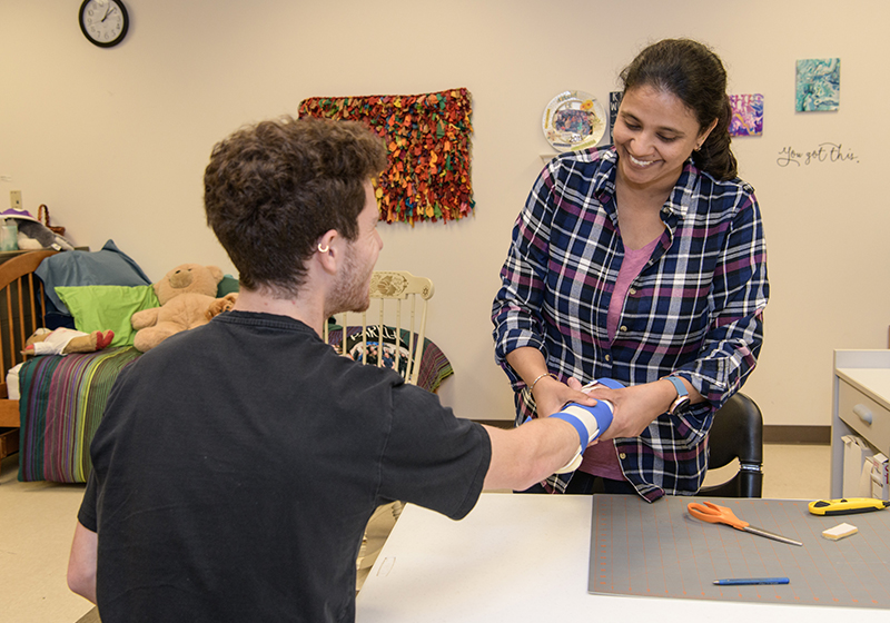 student setting person's arm in brace