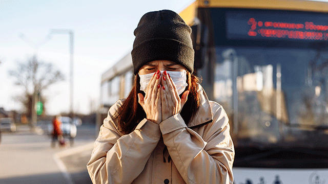 woman sneezing in mask