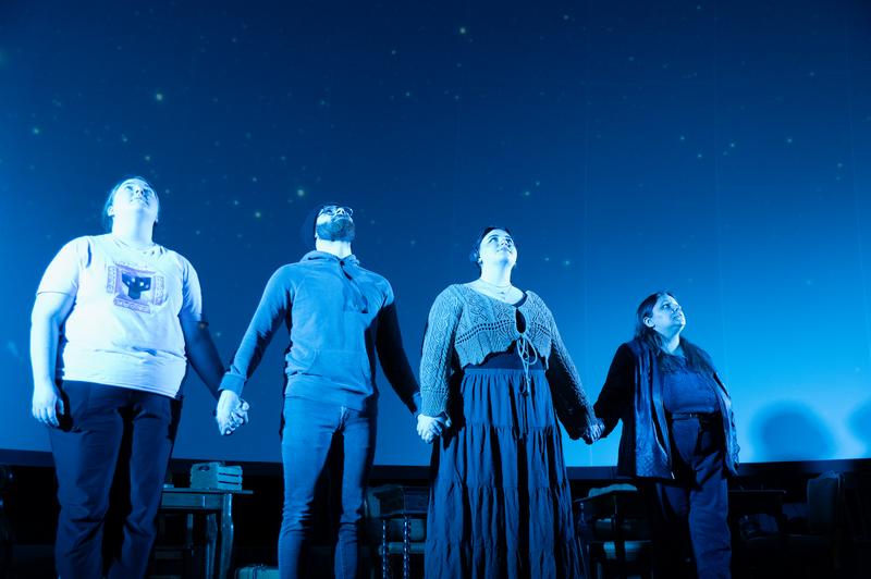 Actors staring at the night sky on stage